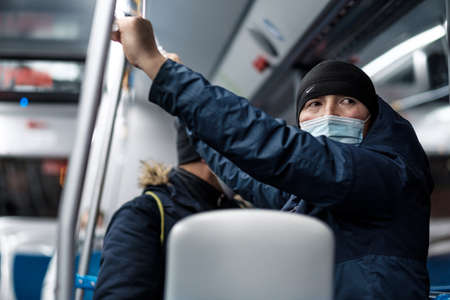 Moscow. Russia. November 11, 2020. A man in a city bus wearing a protective medical mask.のeditorial素材