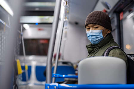 Moscow. Russia. November 16, 2020. A man in a city bus wearing a protective medical mask. Preventive measures for viral infections. The second wave of the coronavirus pandemic.のeditorial素材