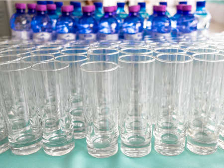 Selective focus on empty clean transparent glasses. There are a lot of bottles with drinks on a...