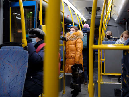 Moscow. Russia. November 24, 2011. A woman in a medical mask is standing on the bus. Measures to minimize virus infection in urban public transport. Coronavirus pandemic.のeditorial素材
