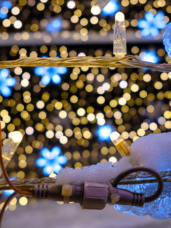 Selective focus on LED Christmas lights. Yellow lights on a blurred background. Magical New Years...