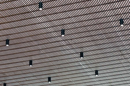 Bright halogen spotlight on the ceiling grille. Abstract background.の写真素材