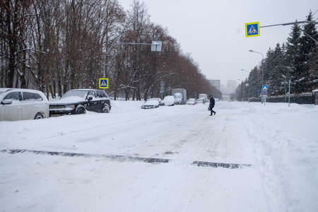 Moscow. Russia. February 13, 2021. Cars parked along the road on a winter day are covered in a thick layer of snow after a heavy snowfall.のeditorial素材