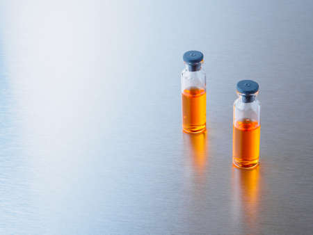 Selective focus. Virus vaccination medical concept. Close-up shot of injection ampoules with orange...