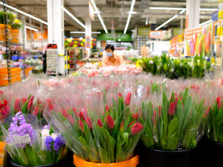 Many red tulips in bouquets, packed in transparent cellophane wrap. Selective focus. Spring flowers in a shop for women on Women's Day on March 8.の写真素材