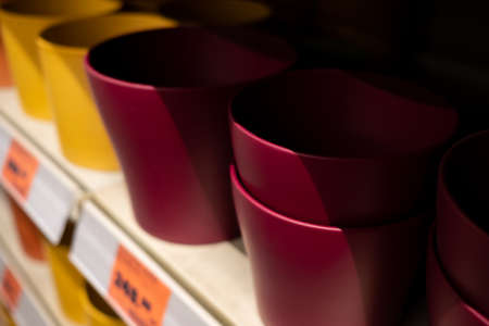 Selective focus on flower pots on a garden store shelf. Ceramic pots in various sizes and colors. Blurred background.の写真素材