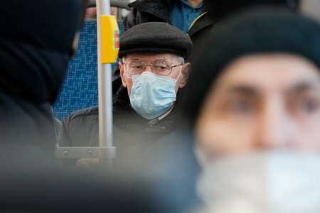 Moscow. Russia. March 26, 2021. Selective focus on the face of an elderly man in a city bus wearing glasses and a protective mask. Prevention and protection against viral infections.のeditorial素材
