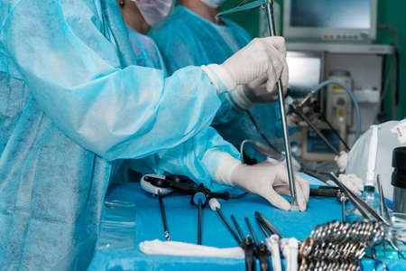 Surgical laparoscopic manipulator in the hands of a surgeon in the operating room. Selective focus. Surgical instrument for minimally invasive proctological surgery in the hands of a doctor.の写真素材