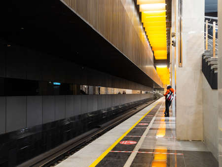 December 8, 2021. Moscow. Russia. A lone passenger on the empty platform of the Novatorskaya subway station is waiting for the train. Launch of the big circle line of the Moscow Metro.のeditorial素材