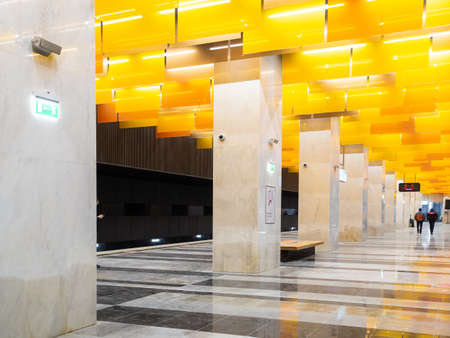 December 8, 2021. Moscow. Russia. Columns and graceful orange ceiling lamps in the interior of the new Novatorskaya subway station on the section of the Moscow Metros big circular line.のeditorial素材