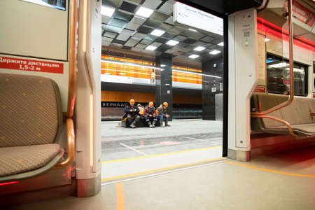 December 8, 2021. Moscow. Russia. Workers in orange helmets sit on a bench in the lobby of the new...