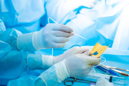 The surgeons hand in a sterile glove holds a fibrin glue dispenser. Fibrin glue is an innovative medical drug for hemostasis.の写真素材