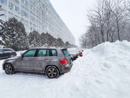 Moscow. Russia. January 18, 2022. City after snowfall and blizzard. Cars are parked on a snowy Moscow street in huge snowdrifts.のeditorial素材