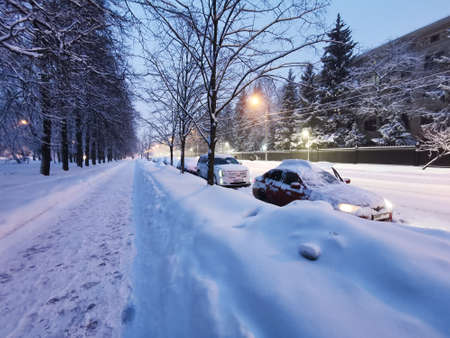 Moscow. Russia. January 18, 2022. Early morning in the city after snowfall and blizzard. Cars covered with snow are parked on a snow-covered street in Moscow in huge snowdrifts.のeditorial素材