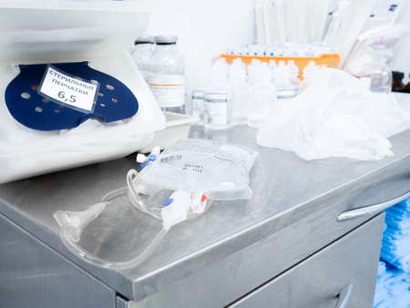 Moscow. Russia. December 24, 2021. Transparent package with saline solution for intravenous drip in the hospital on the table.のeditorial素材