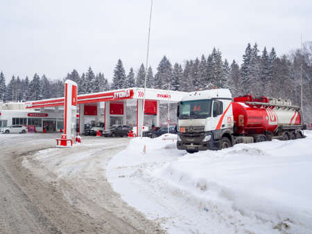 Moscow region. Russia. January 29, 2022. A Mercedes Benz tank truck unloads at a Lukoil gas station during a heavy snowfall on a winter day.のeditorial素材