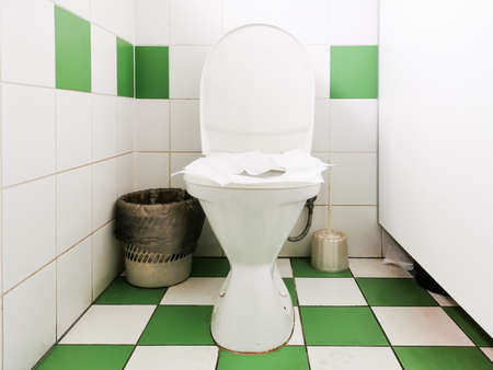 Toilet paper on the toilet seat. Napkins on the toilet seat in a public restroom.の写真素材