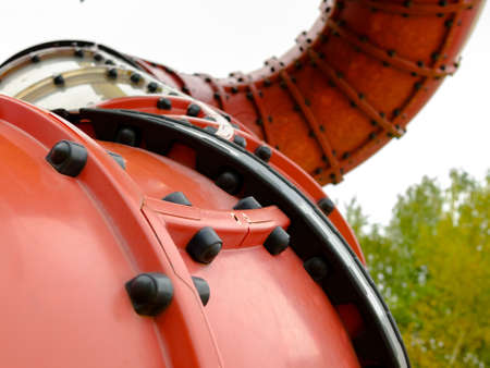 Selective focus on the articulation fragment of the elements of a large red curved pipe for riding on the childrens playground.の写真素材