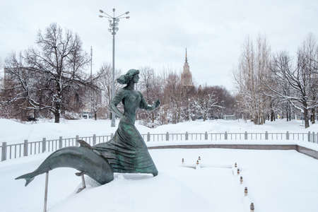 Moscow. Russia. April 3, 2022. Sculptural statue of a girl and a dolphin against the backdrop of a snowy park.のeditorial素材