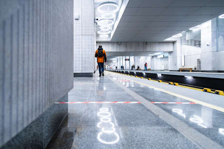 Moscow. Russia. December 7, 2021. Silhouettes of passengers in the interior of the new modern station Terekhovo in the Moscow metro. Brightly lit platform of the Moscow metro station.のeditorial素材