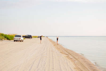 Krasnodar region. Russia. August 10, 2021. People and cars on a sandy beach by the sea. Travel to the sea by car.のeditorial素材