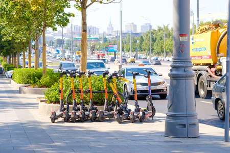 Moscow. Russia. June 9, 2022. Many electric scooters for rent on the sidewalk in the city. Selective focus. The concept of using zero-emission electric rental vehicles in the city.のeditorial素材