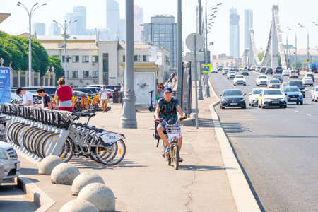 Moscow. Russia. June 9, 2022. A man rides a bicycle along a Moscow street. Selective focus. Cycling along the city street on a sunny day.のeditorial素材