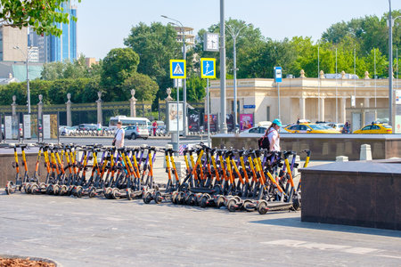 Moscow. Russia. June 9, 2022. Many electric scooters are waiting for rent on the sidewalk in the city on a summer sunny day. Selective focus. The concept of using zero-emission vehicles.のeditorial素材