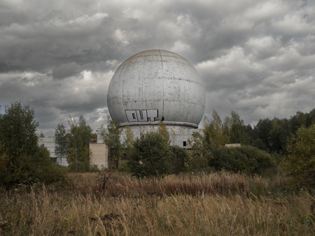 Moscow region. Russia. September 16, 2022. Abandoned spherical concrete building of a radar installation in a forest against a rainy sky. A gloomy landscape with the ruins of a bygone era.のeditorial素材