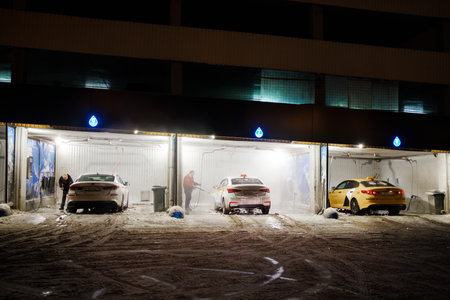 Moscow. Russia. November 18, 2022. Washing taxi cars at a self-service car wash on a winter night.のeditorial素材