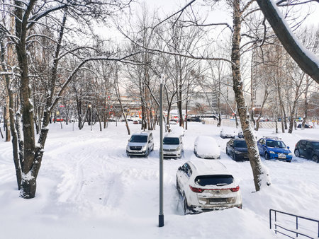 Moscow. Russia. December 15, 2022. Cars in a snow-covered parking lot during the day after a December snowfall.のeditorial素材
