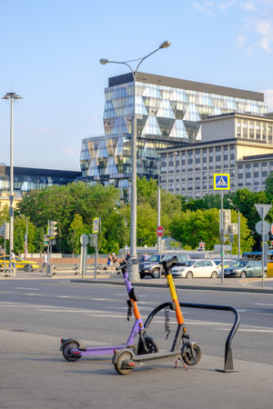 Two electric scooters are parked on a city street on a sunny summer day. Moscow. Russia. June 16, 2023.のeditorial素材