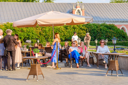 People sit on the veranda of a summer cafe in the park. People rest in the park on a summer sunny day. Moscow. Russia. June 16, 2023.のeditorial素材