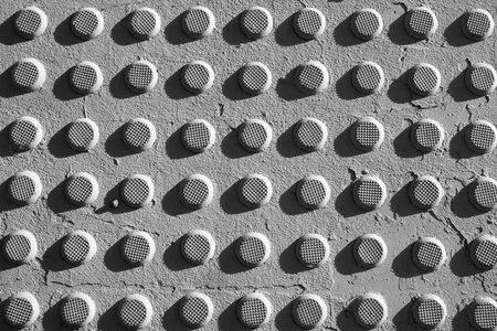 Textured iron rivets on a concrete surface. Black and white photo.の写真素材