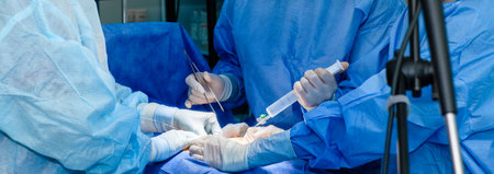 Hands of doctors and nurses in sterile gloves perform a surgical operation in the emergency department of a hospital. Surgeons operate with surgical instruments.の写真素材