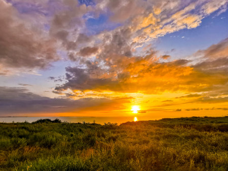 Beautiful sunset over the sea. Sun and colorful clouds at sunset over the seashore.の写真素材
