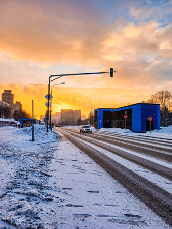 View of a city street against the backdrop of a picturesque sunset on a winter evening. Snowflakes fly in the air. Moscow. Russia. February 6, 2024.のeditorial素材