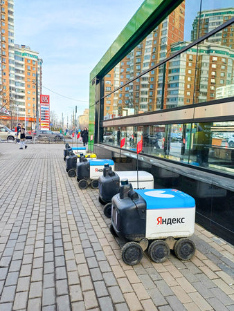 Several Yandex delivery robots are parked on a sidewalk in Moscow on a sunny spring day. Moscow. Russia. March 22, 2024.のeditorial素材