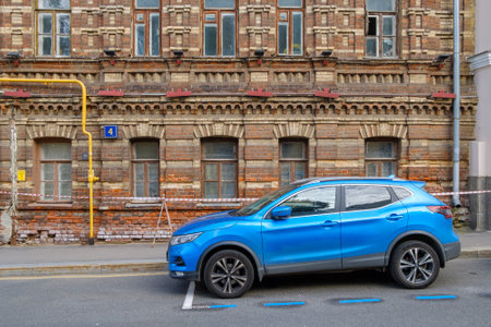 A blue Nissan Qashqai, a modern compact crossover SUV, is parked next to an old brick building in the city. Moscow. Russia. July 2, 2024.のeditorial素材