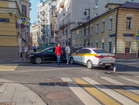 Car accident on a city street on a summer day. A taxi car collided with a car. Moscow. Russia. July 2, 2024. High quality photoのeditorial素材