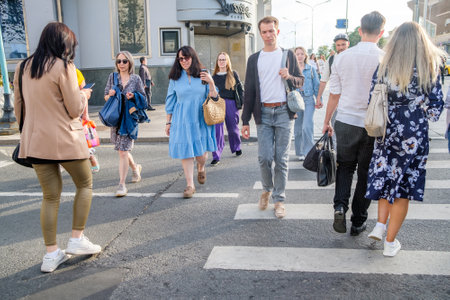 Women and men cross the street at a pedestrian crossing on a summer day. Moscow. Russia. July 2, 2024.のeditorial素材