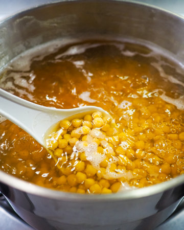 Chickpeas being cooked in boiling water in a saucepan. View from above. Cooking yellow chickpeas. Middle Eastern cuisine.の写真素材
