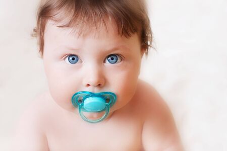portrait of baby with soother on white backgroundの写真素材