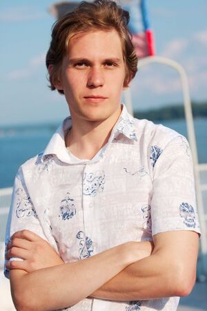 portrait of young man in white t-short on sky backgroundの写真素材