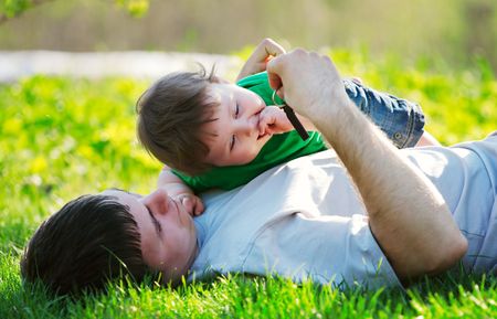 father and son playing on the grassの写真素材
