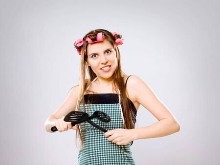 portrait of crazy housewife with kitchen utensilsの写真素材