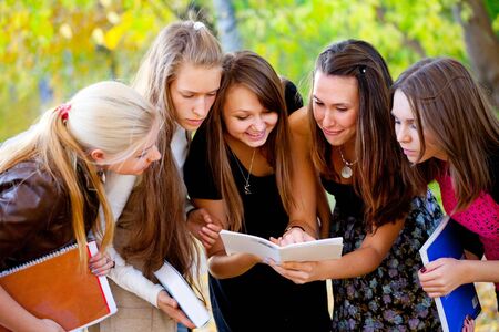Students with books on nature backgroundの写真素材