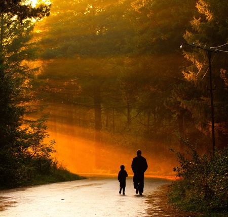 father and son walking in the sunlightの写真素材