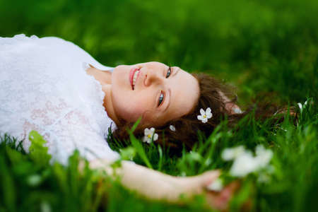 portrait of beautiful woman lying on the grassの写真素材