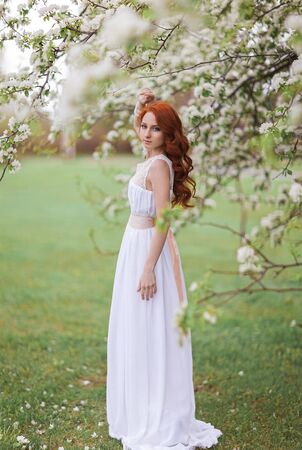 Beautiful woman in the flowering parkの写真素材